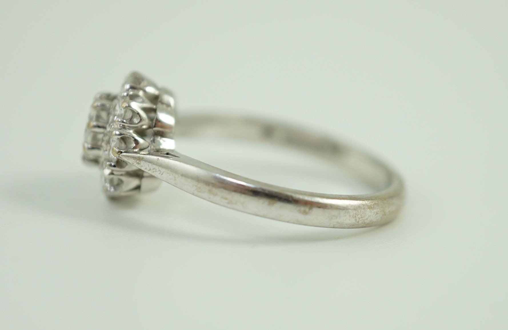 A modern 18ct white gold and nine stone diamond set flower head cluster ring